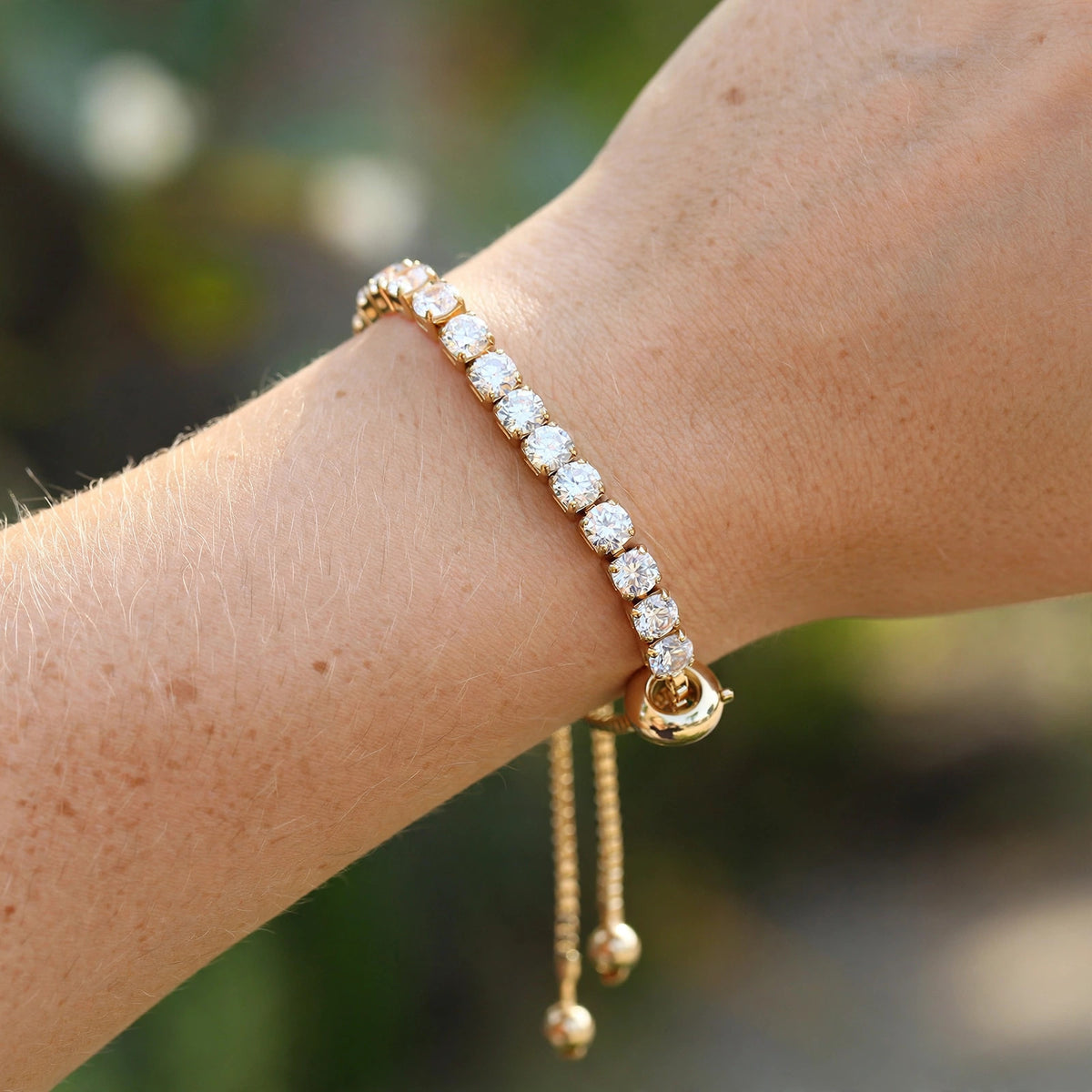 Gold tennis bracelet worn on wrist